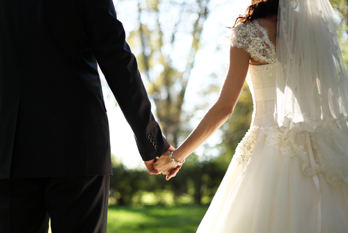 Love and friends couple in wedding dress holding hands